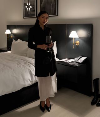 Dawn wears a black coat, white sheer skirt, and black pumps.