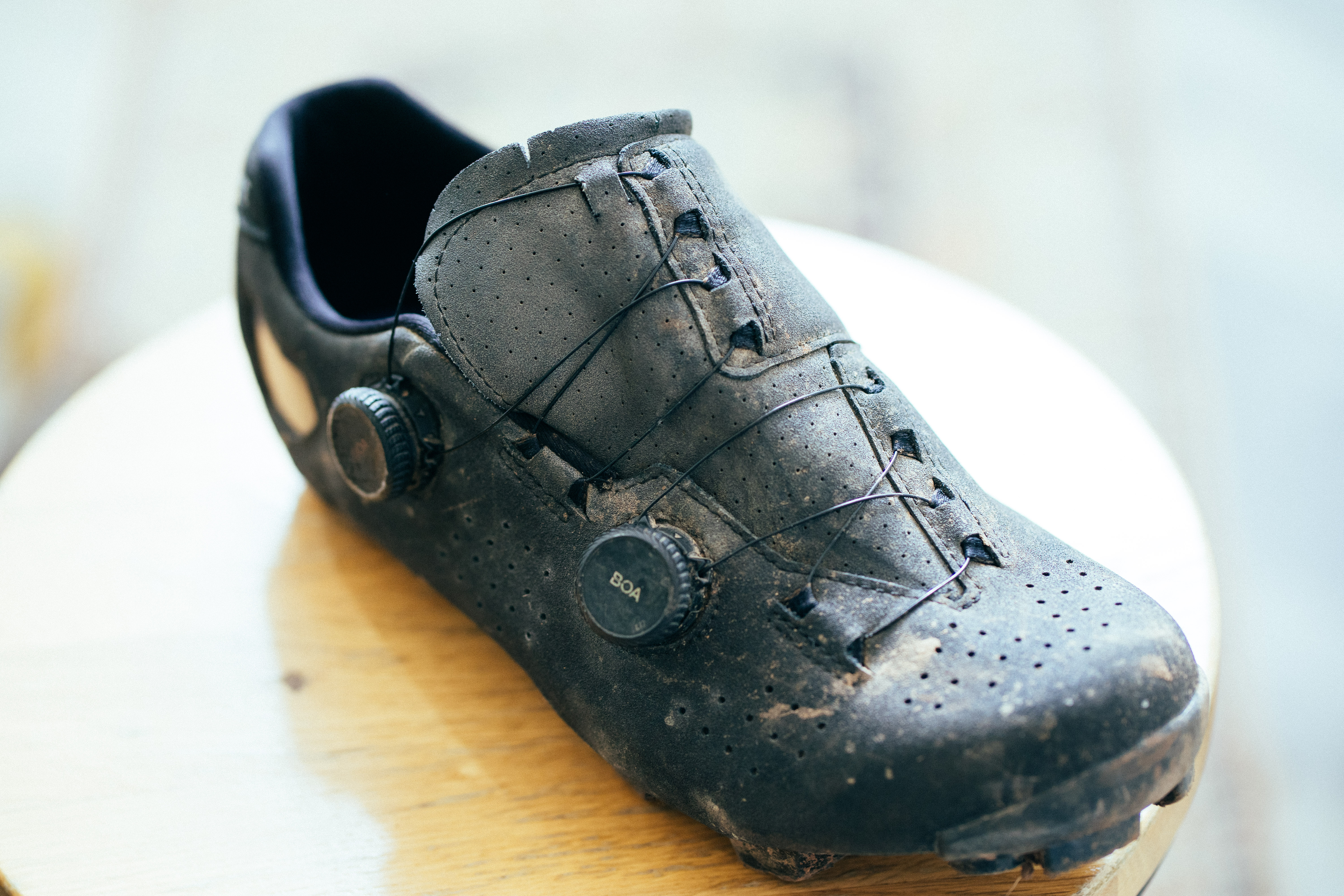 A top down view of a black gravel shoe on a wooden stool