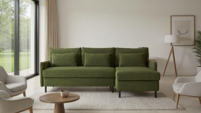 Image of a dark green sofa in a neutral living room. There are three other beige chairs around the sofa and a beige rug on the ground.
