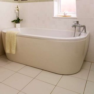 white tiled bathroom with bathtub