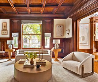 parlor with wood paneling modern art and cream sofas