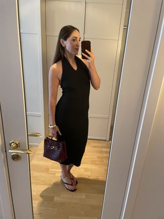 Anna LaPlaca wearing a black halter dress and Alexis Bittar molten cuff