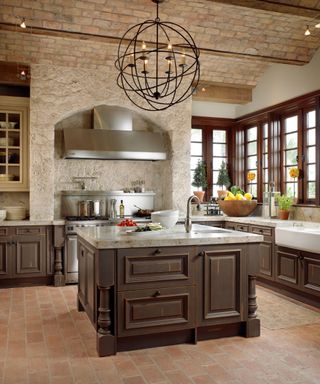 Tuscan kitchen with dark wood cabinets and terracotta flooring