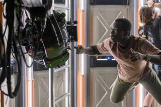 Ato Essandoh (Kwesi) floats in space with the help of wires on the ground in Episode 101 of "Away" on Netflix.