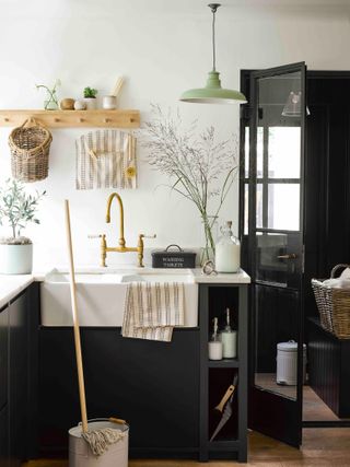 laundry room with wooden hooks, a gold tap and blue built in units