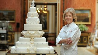 Fiona Cairns stands next to the Royal Wedding cake that she and her team made for Prince William and Kate Middleton, in the Picture Gallery of Buckingham Palace in London on April, 29, 2011. AFP PHOTO / WPA POOL / JOHN STILLWELL