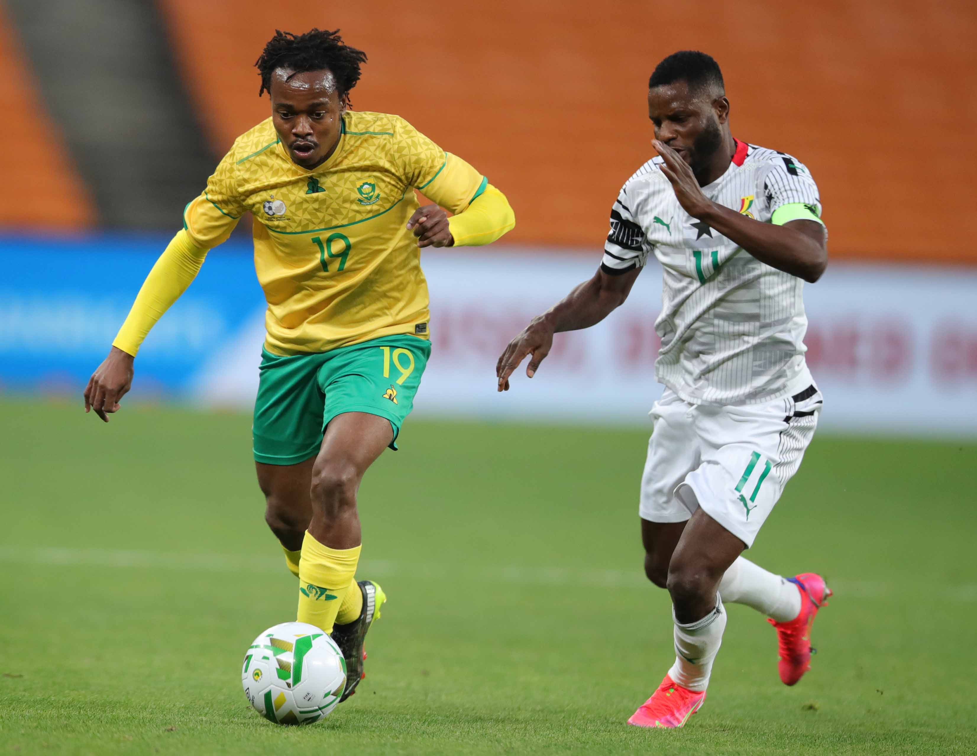 Percy Tau of South Africa challenged by Wakaso Mubarak of Ghana