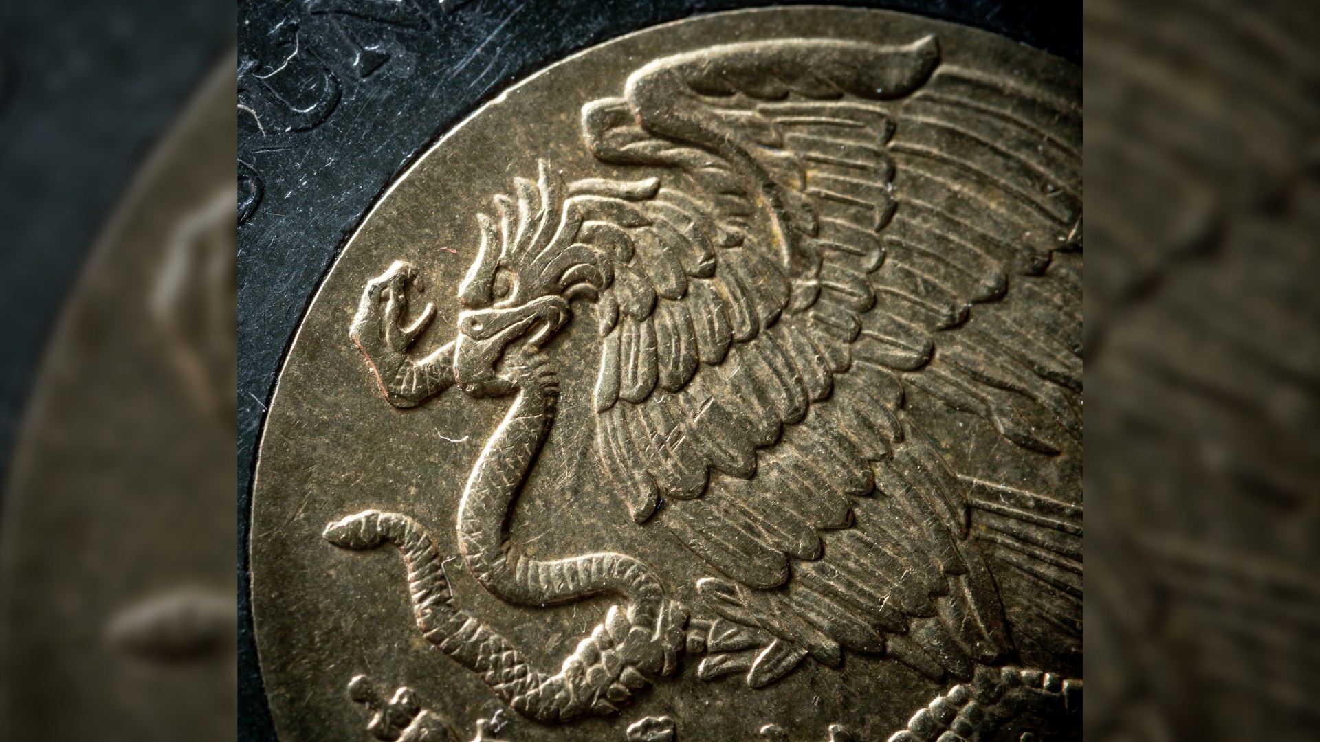A close up image of a Mexican peso. It shows an eagle — a potent symbol in Aztec ideology — with a rattlesnake in its beak.