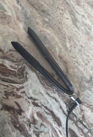 GHD Platinum+ hair straightener on marble surface