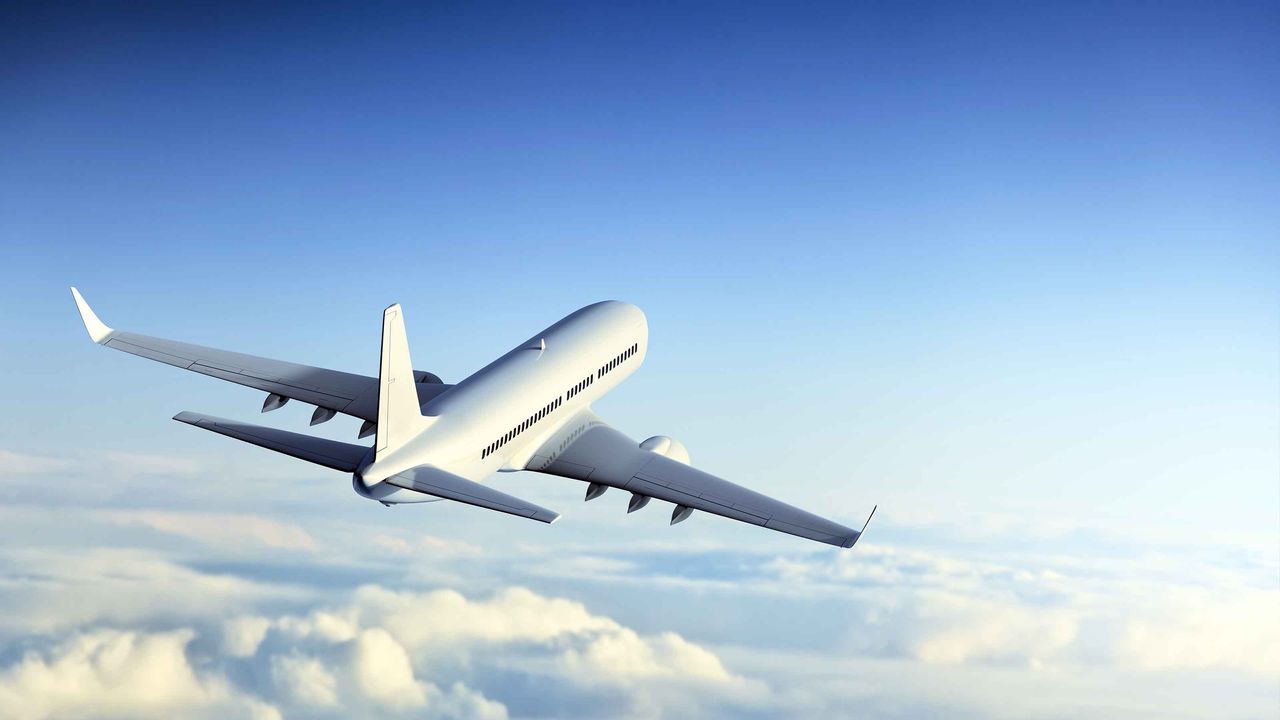 A plane flies above the clouds