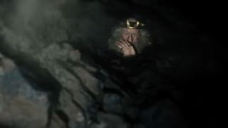 A character staring out of a hole in The Lord of Rings: The Rings of Power Season 2.
