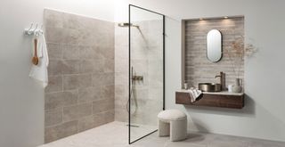 Neutral bathroom with tectured brown tiles in a shower area and creating a feature wall behind the mirror above the sink as a new bathroom trend 2023