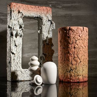 Various ceramics in grey and orange displayed on a table.