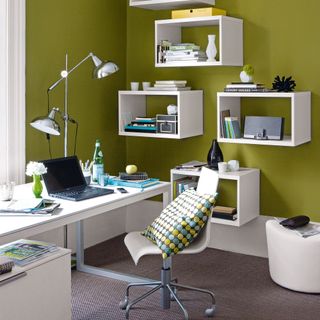 Green home office with white furniture, floating shelving units and double light