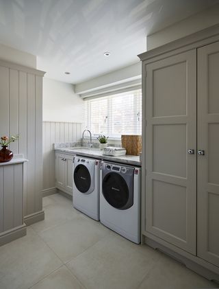 grey laundry room with natural floor tiles by Martin Moore