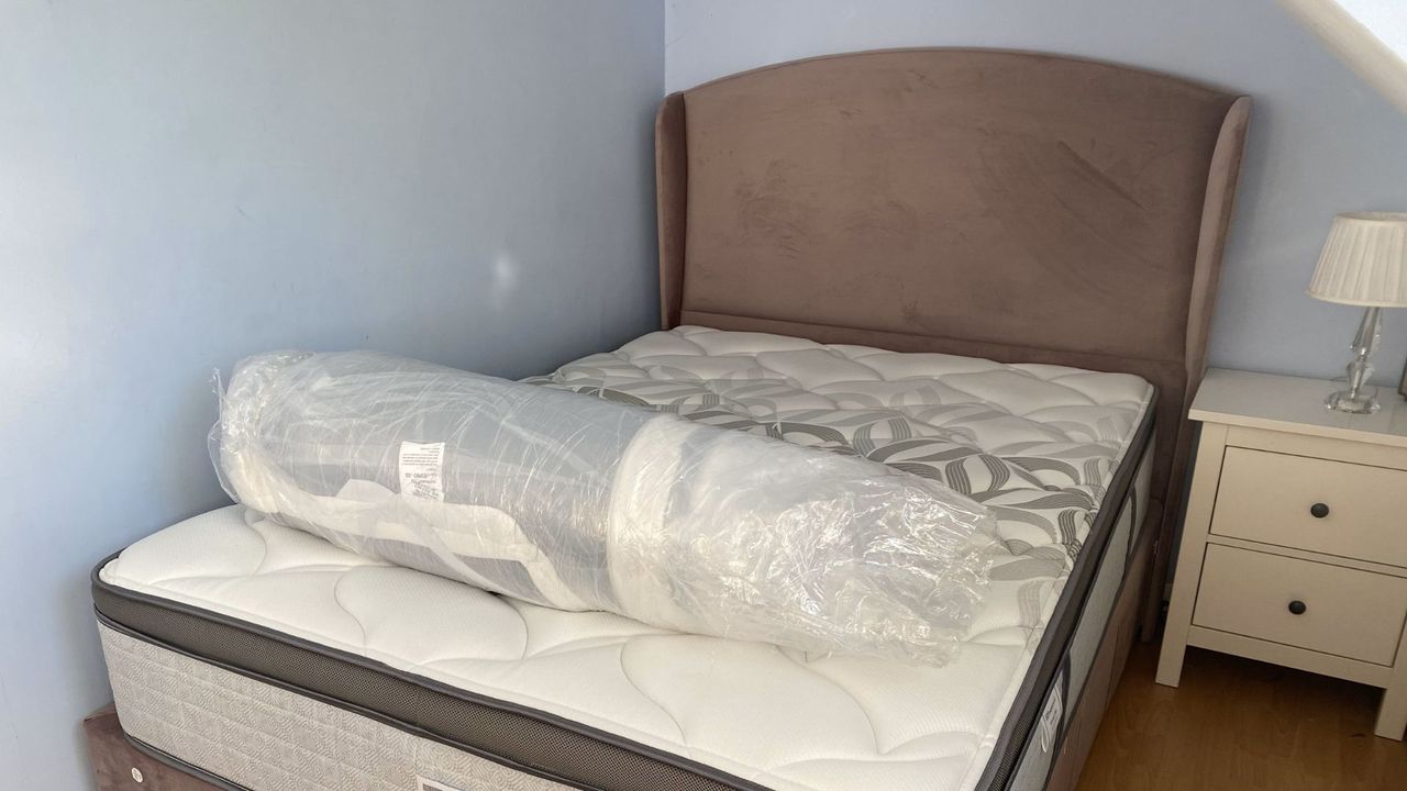 The Helix GlacioTex Premium Mattress Topper still rolled up on top of bed