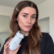 A selfie of Eleanor holding the NuFace Trinity device to camera after using it