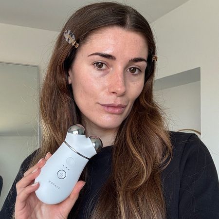 A selfie of Eleanor holding the NuFace Trinity device to camera after using it