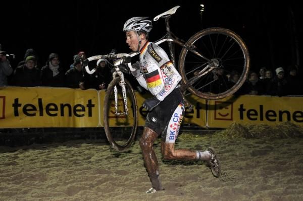 German national champion Philipp Walsleben (BKCP-Powerplus) shoulders his bike through the sand.
