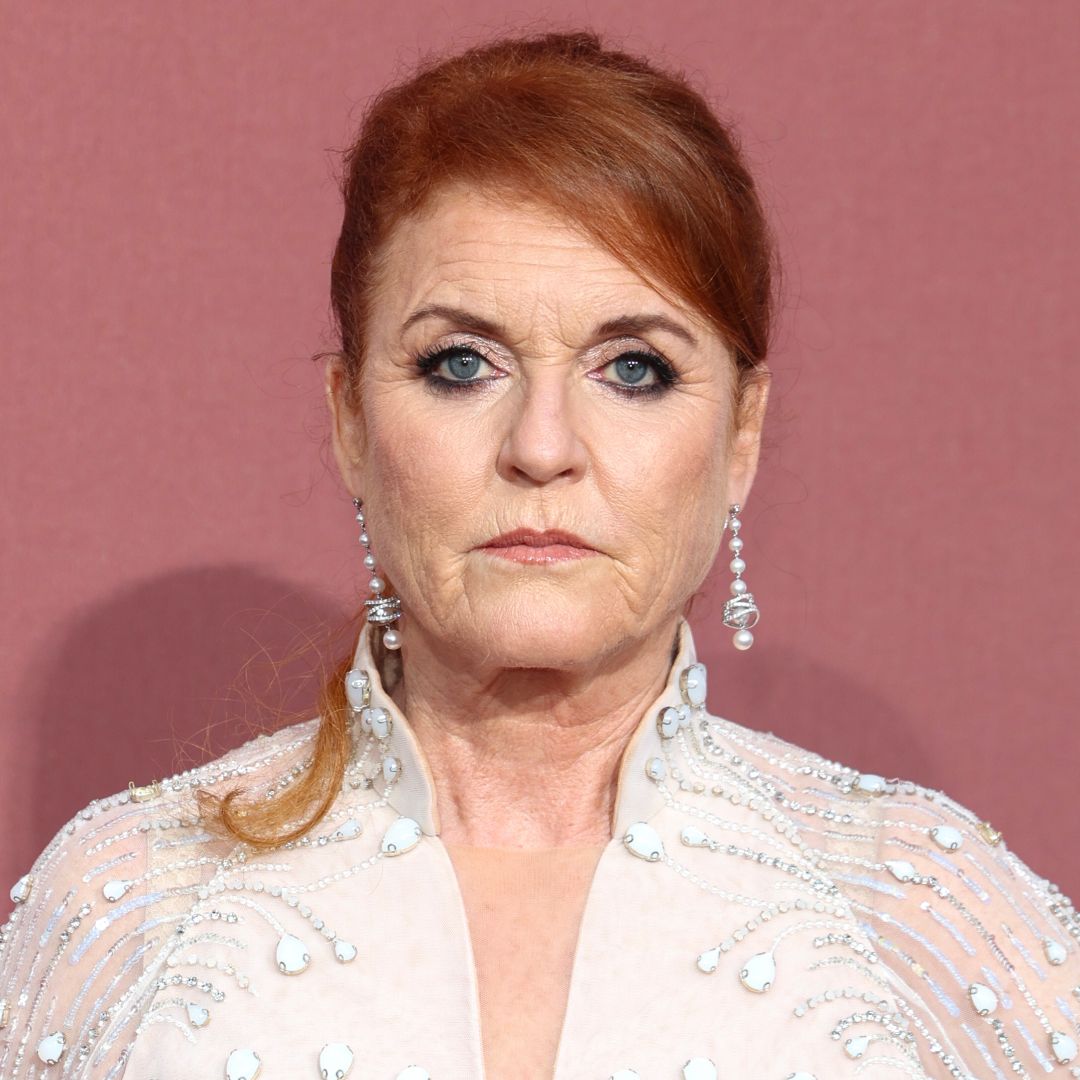 Sarah Ferguson looks worried while wearing diamond drop earrings and a white sheer dress adorned with crystals