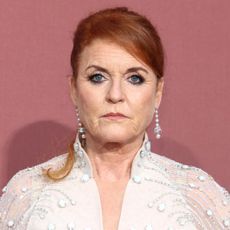 Sarah Ferguson looks worried while wearing diamond drop earrings and a white sheer dress adorned with crystals