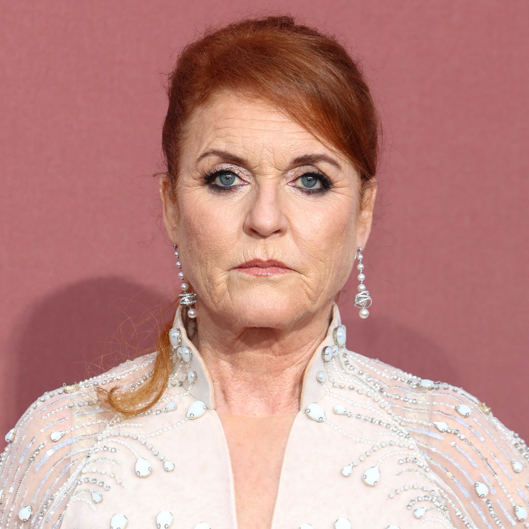 Sarah Ferguson looks worried while wearing diamond drop earrings and a white sheer dress adorned with crystals