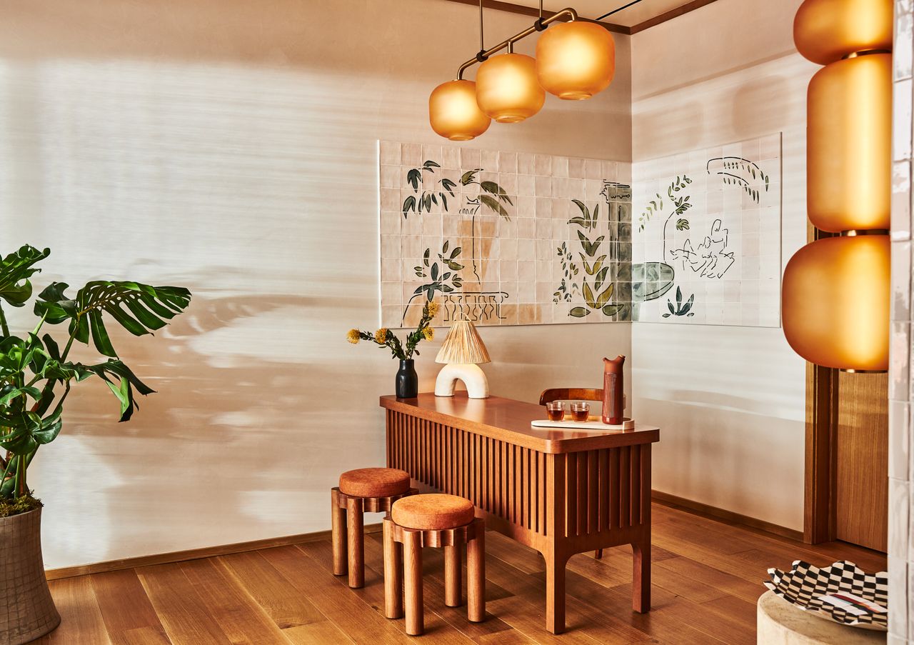 Lobby at the Alsace Hotel with a tiled mural and wooden desk