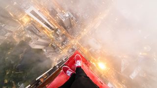 NFT photography; a man stands on a building ledge in the fog