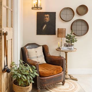 old leather armchair with hession cushion beside a side table and framed picture on the wall