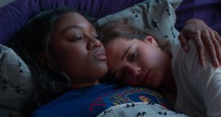 two girls lay in bed together in a still from Netflix's 'First Kill'