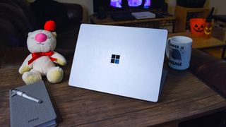 Microsoft Surface Laptop 4 on a coffee table next to a notebook and a coffee cup