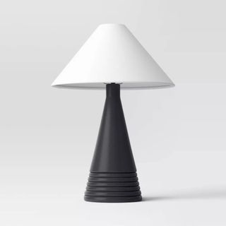 A black tapered base lamp with a white lampshade