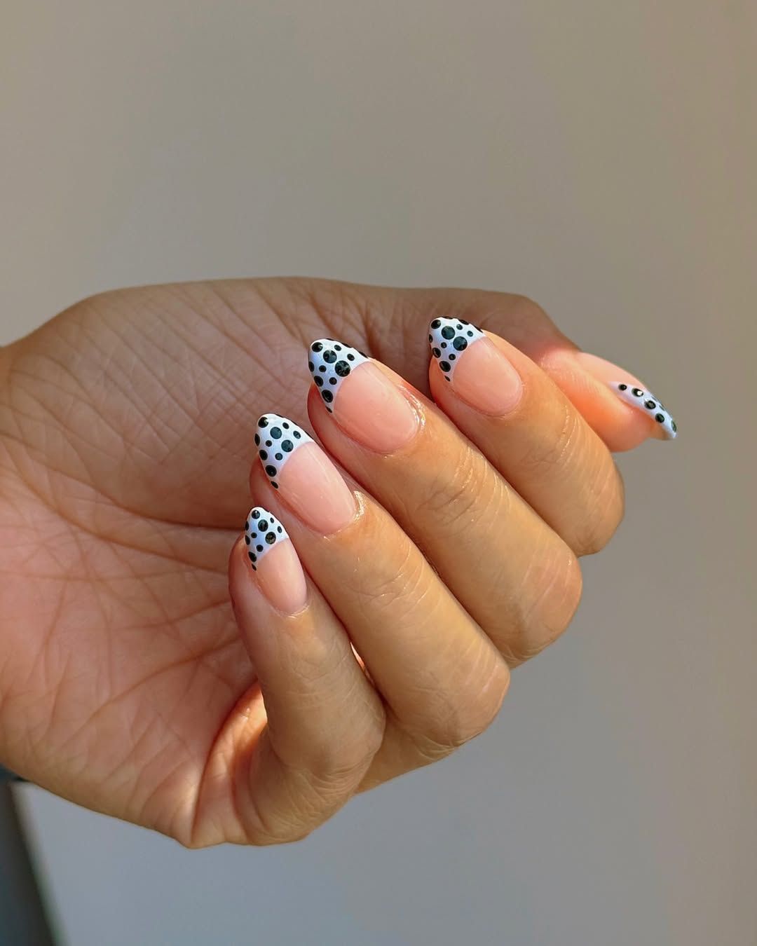 A manicure with polka dot nail art by Queenie Nguyen