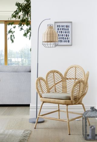 white living room with rattan armchair and pendant light