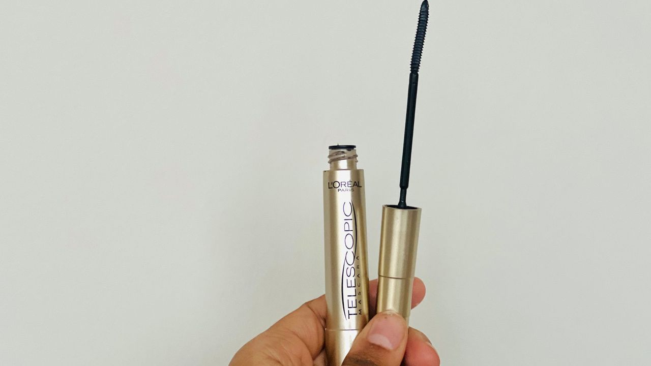 A person holding an opened L'Oreal Telescopic Mascara tube, for L'Oreal Telescopic Mascara review.
