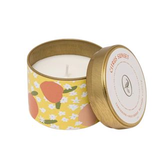 A citrus candle in a yellow patterned tin