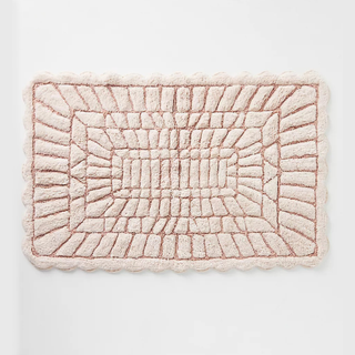 A light pink tufted bath mat 