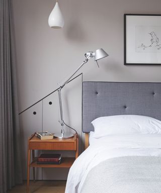 A teenage boys bedroom idea with grey upholstered headboard, warm grey walls, wooden bedside table and anglepoise lamp