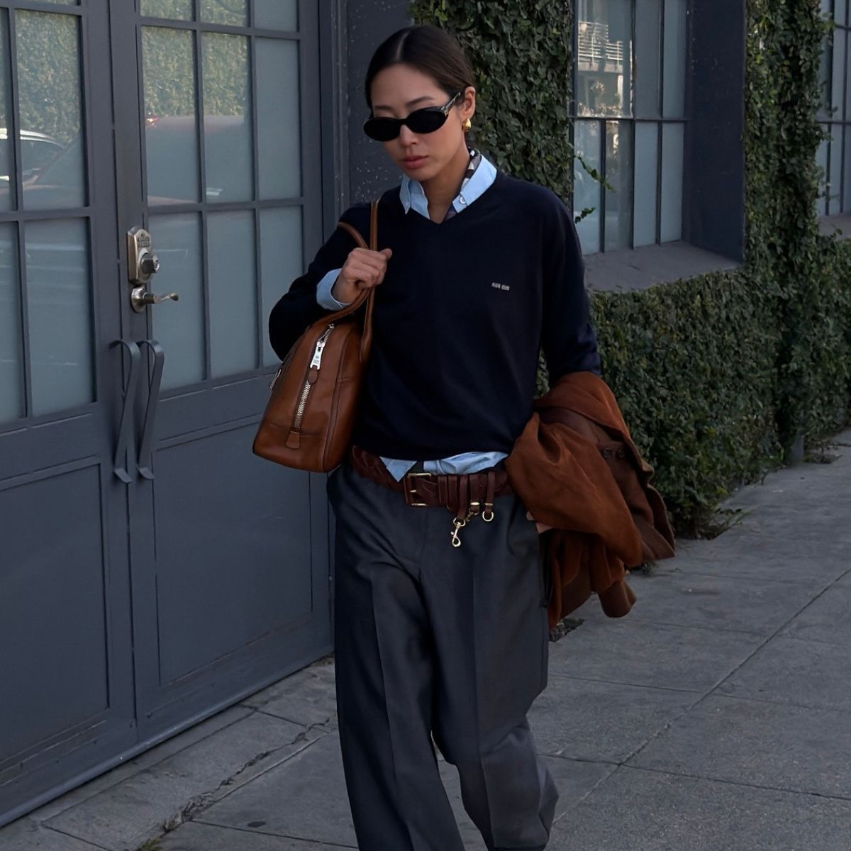 Woman wears white shirt, blue jeans, carries large tote bag