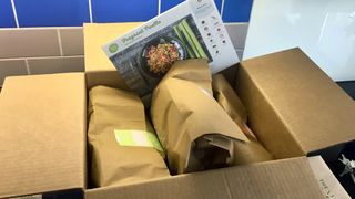 Three Hello Fresh meals, bagged, in their chilled delivery box