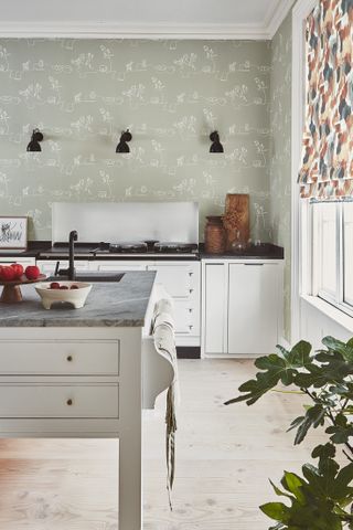 Kitchen with white base cabinets and kitchen island, green pattern wallpaper