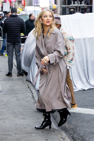 A photo of Kate Hudson accessorizing her outfit with black Khaite boots and square pavé hoop earrings.