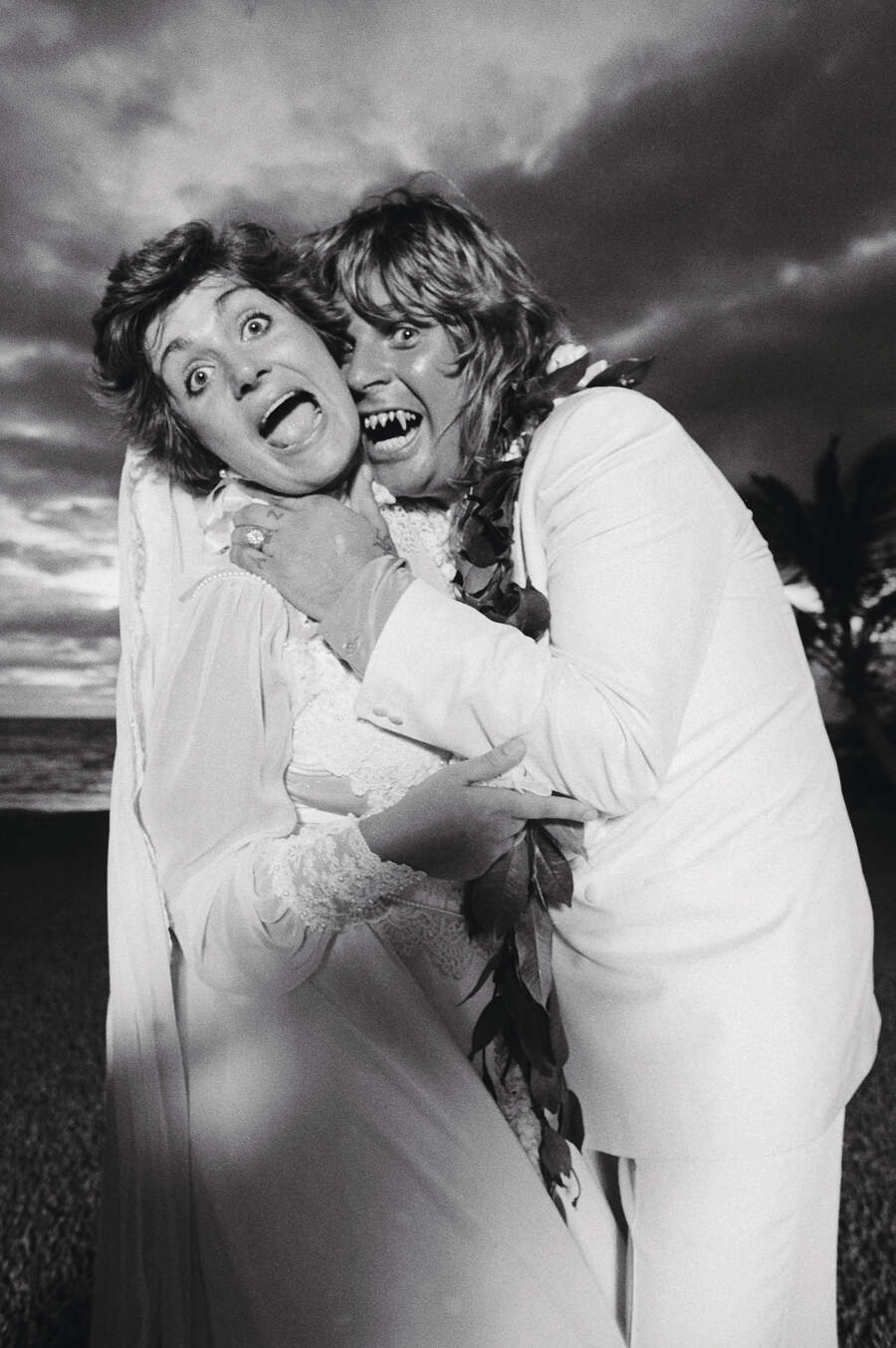 Ozzy and Sharon Osbourne on their wedding day. Ozzy is pretending to bite Sharon&#039;s neck