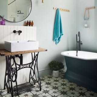 bathroom with blue bath and old singer sewing table washstand