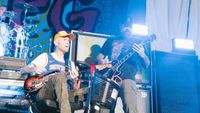 Chad Gilbert playing guitar on stage while in a wheelchair