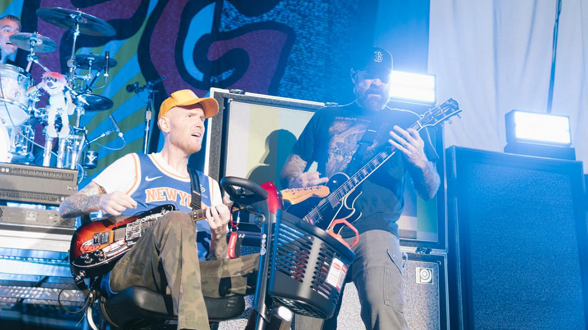 Chad Gilbert playing guitar on stage while in a wheelchair