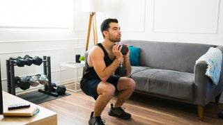 A man performing a dumbbell goblet squat