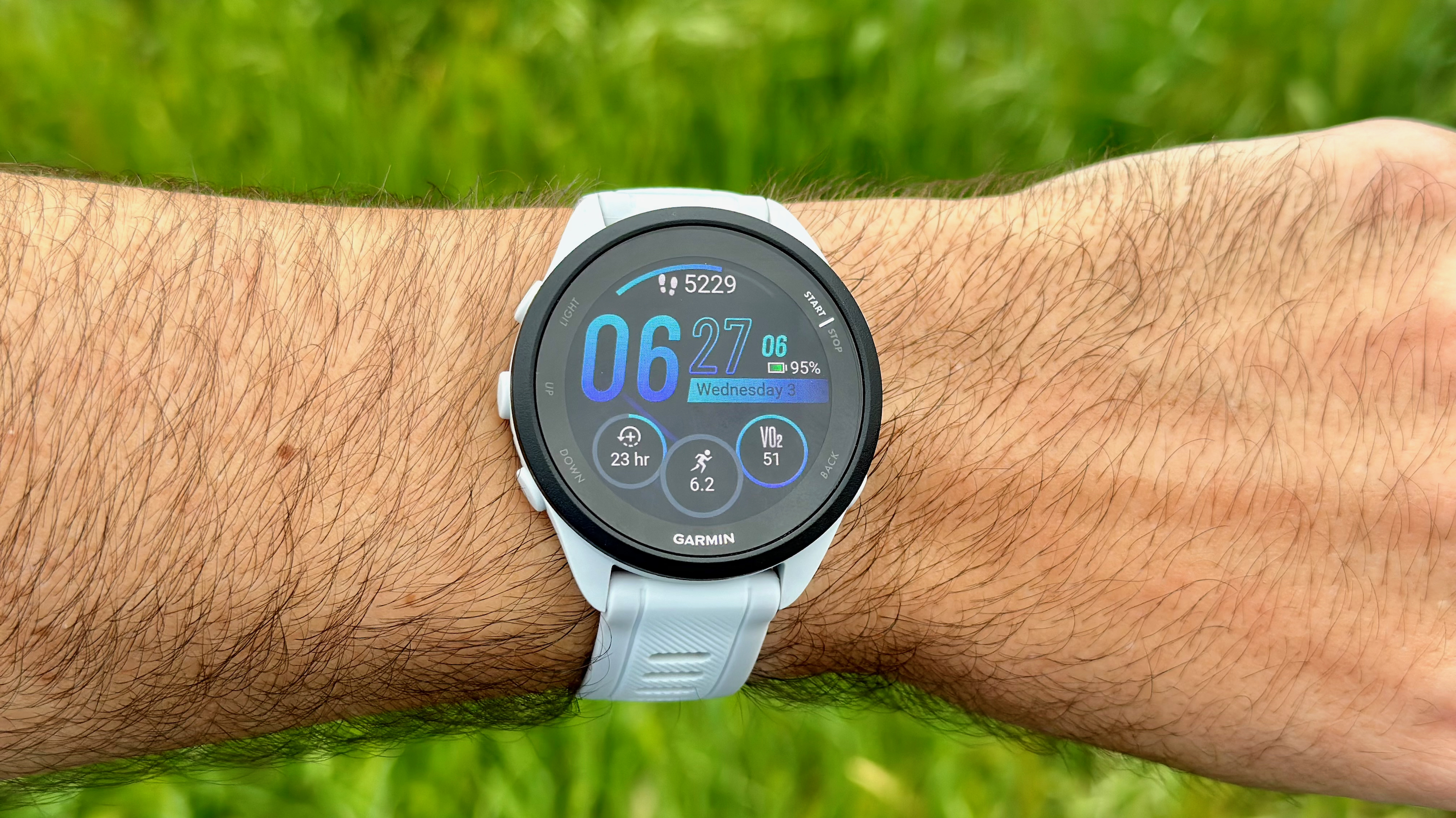 Close up of the Garmin Forerunner 165's default watch face, showing steps, the time, miles run that week, recovery time estimate, and VO2 Max estimate.