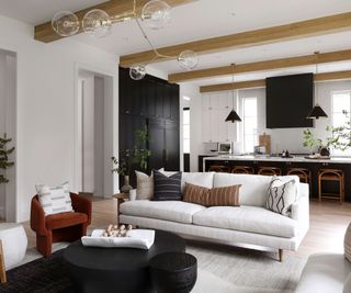White 3-seater couch floating in an open plan living room and kitchen space with grey/neutral color scheme and modern interiors