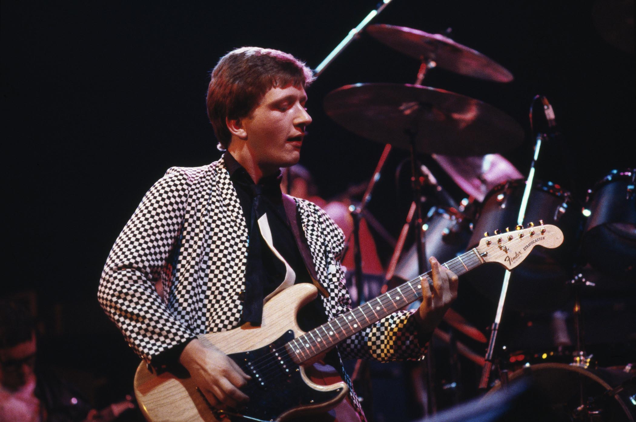 Glenn Tilbrook of Squeeze performing in 1979 with a Strat and a black-and-white checked jacket
